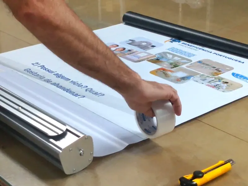 Como trocar o banner do roll up, passo 6: fita transparente reforçando a emenda